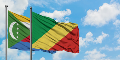 Comoros and Republic Of The Congo flag waving in the wind against white cloudy blue sky together. Diplomacy concept, international relations.