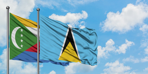 Comoros and Saint Lucia flag waving in the wind against white cloudy blue sky together. Diplomacy concept, international relations.