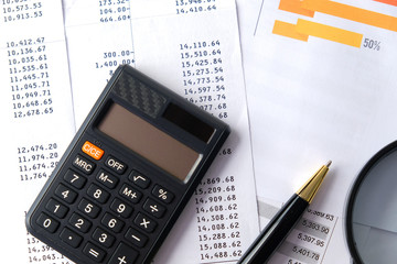 Pen, calculator with magnifier and account reports. Business and Finance concepts