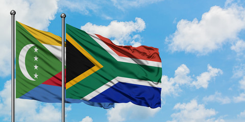 Comoros and South Africa flag waving in the wind against white cloudy blue sky together. Diplomacy concept, international relations.