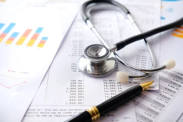 Stethoskop mit Stift, Diagrammen und Grafiken, Finanzen, Konto, Statistiken, Investitionen, analytische Forschungsdaten, Wirtschaftlichkeitstabelle und Unternehmenskonzept © shahrilkhmd