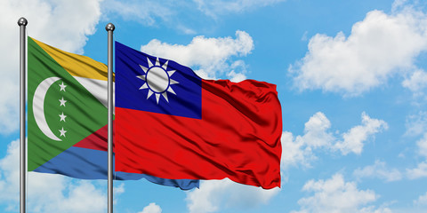 Comoros and Taiwan flag waving in the wind against white cloudy blue sky together. Diplomacy concept, international relations.