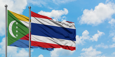 Comoros and Thailand flag waving in the wind against white cloudy blue sky together. Diplomacy concept, international relations.