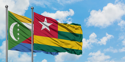 Comoros and Togo flag waving in the wind against white cloudy blue sky together. Diplomacy concept,...