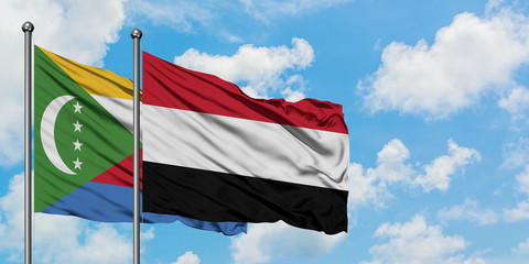 Comoros and Yemen flag waving in the wind against white cloudy blue sky together. Diplomacy concept, international relations.