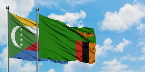 Comoros and Zambia flag waving in the wind against white cloudy blue sky together. Diplomacy...