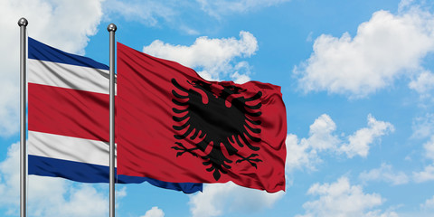 Costa Rica and Albania flag waving in the wind against white cloudy blue sky together. Diplomacy concept, international relations.