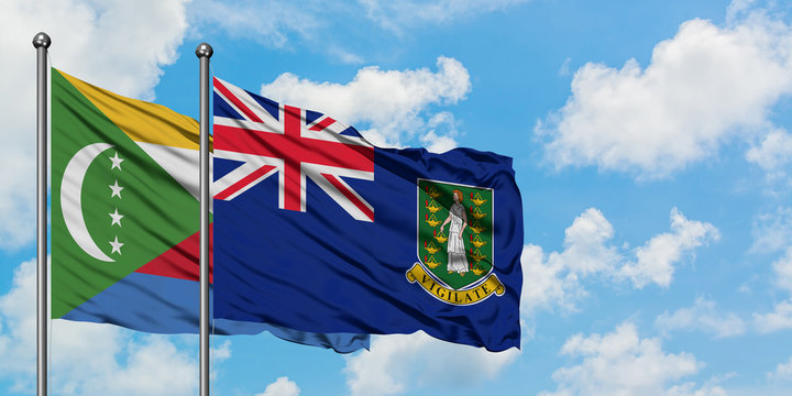 Comoros and British Virgin Islands flag waving in the wind against white cloudy blue sky together. Diplomacy concept, international relations.