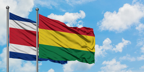 Costa Rica and Bolivia flag waving in the wind against white cloudy blue sky together. Diplomacy concept, international relations.