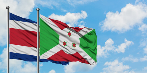 Costa Rica and Burundi flag waving in the wind against white cloudy blue sky together. Diplomacy concept, international relations.