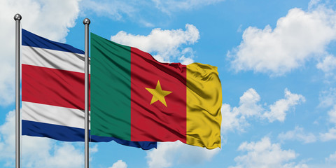 Costa Rica and Cameroon flag waving in the wind against white cloudy blue sky together. Diplomacy concept, international relations.