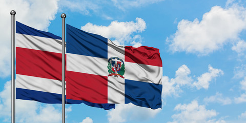 Costa Rica and Dominican Republic flag waving in the wind against white cloudy blue sky together. Diplomacy concept, international relations.