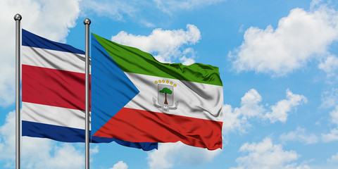 Costa Rica and Equatorial Guinea flag waving in the wind against white cloudy blue sky together. Diplomacy concept, international relations.