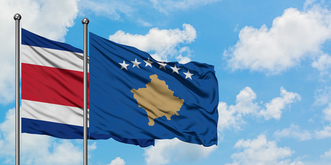 Costa Rica and Kosovo flag waving in the wind against white cloudy blue sky together. Diplomacy concept, international relations.