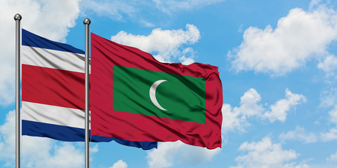 Costa Rica and Maldives flag waving in the wind against white cloudy blue sky together. Diplomacy concept, international relations.