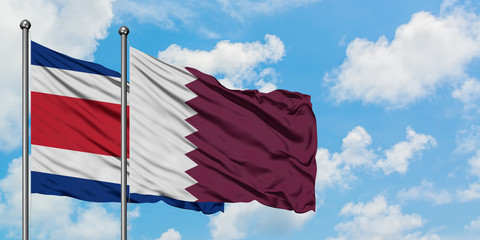 Costa Rica and Qatar flag waving in the wind against white cloudy blue sky together. Diplomacy concept, international relations.