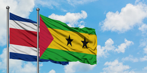 Costa Rica and Sao Tome And Principe flag waving in the wind against white cloudy blue sky together. Diplomacy concept, international relations.