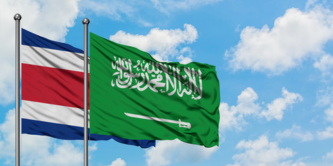 Costa Rica and Saudi Arabia flag waving in the wind against white cloudy blue sky together. Diplomacy concept, international relations.