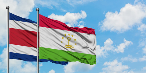 Costa Rica and Tajikistan flag waving in the wind against white cloudy blue sky together. Diplomacy concept, international relations.