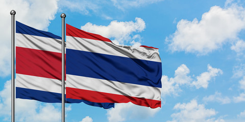 Costa Rica and Thailand flag waving in the wind against white cloudy blue sky together. Diplomacy concept, international relations.