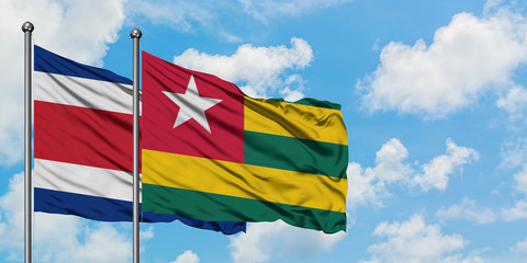 Costa Rica and Togo flag waving in the wind against white cloudy blue sky together. Diplomacy concept, international relations.