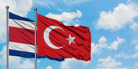 Costa Rica and Turkey flag waving in the wind against white cloudy blue sky together. Diplomacy concept, international relations.