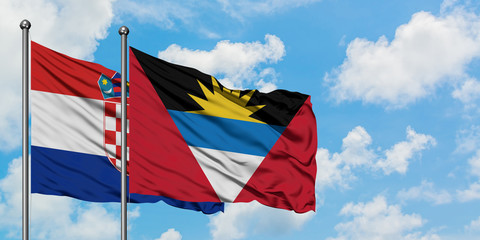 Croatia and Antigua and Barbuda flag waving in the wind against white cloudy blue sky together....