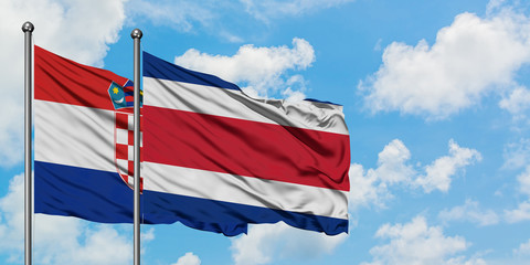 Croatia and Costa Rica flag waving in the wind against white cloudy blue sky together. Diplomacy concept, international relations.