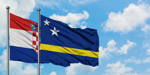 Croatia and Curacao flag waving in the wind against white cloudy blue sky together. Diplomacy concept, international relations.