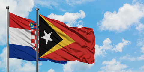 Croatia and East Timor flag waving in the wind against white cloudy blue sky together. Diplomacy concept, international relations.