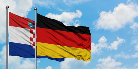 Croatia and Germany flag waving in the wind against white cloudy blue sky together. Diplomacy concept, international relations.