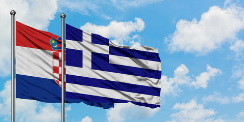 Croatia and Greece flag waving in the wind against white cloudy blue sky together. Diplomacy concept, international relations.