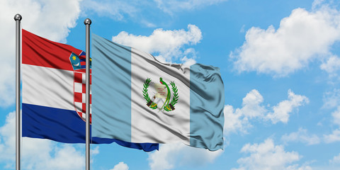 Croatia and Guatemala flag waving in the wind against white cloudy blue sky together. Diplomacy...