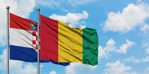 Croatia and Guinea flag waving in the wind against white cloudy blue sky together. Diplomacy concept, international relations.