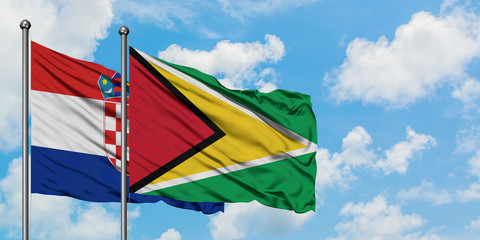 Croatia and Guyana flag waving in the wind against white cloudy blue sky together. Diplomacy concept, international relations.