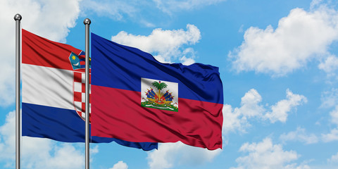 Croatia and Haiti flag waving in the wind against white cloudy blue sky together. Diplomacy...