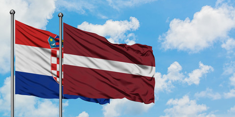 Croatia and Latvia flag waving in the wind against white cloudy blue sky together. Diplomacy concept, international relations.