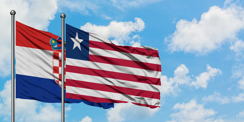 Croatia and Liberia flag waving in the wind against white cloudy blue sky together. Diplomacy concept, international relations.