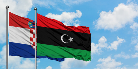 Croatia and Libya flag waving in the wind against white cloudy blue sky together. Diplomacy concept, international relations.