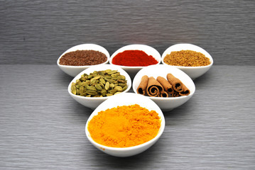 Healthy Spices Flax Seed, Chili Powder,  Fenugreek, Turmeric, Cardamom, and Cinnamon in a triangle