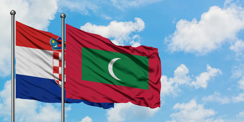 Croatia and Maldives flag waving in the wind against white cloudy blue sky together. Diplomacy...