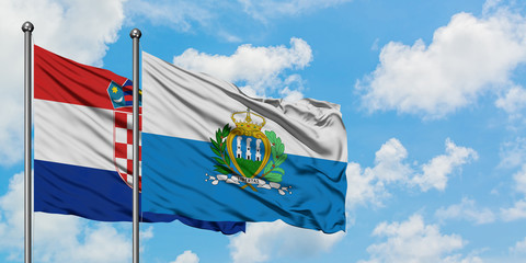 Croatia and San Marino flag waving in the wind against white cloudy blue sky together. Diplomacy concept, international relations.