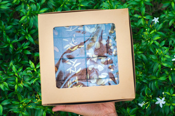 Fudge brownies in a brown paper box on hand