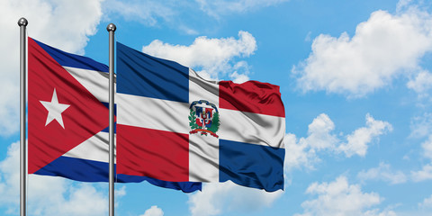 Cuba and Dominican Republic flag waving in the wind against white cloudy blue sky together. Diplomacy concept, international relations.