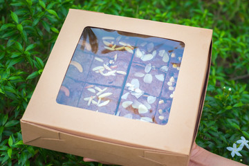Fudge brownies in a brown paper box on hand