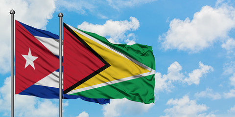 Cuba and Guyana flag waving in the wind against white cloudy blue sky together. Diplomacy concept, international relations.