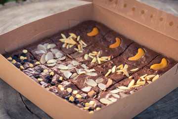 Fudge brownies in a brown paper box on wooden table