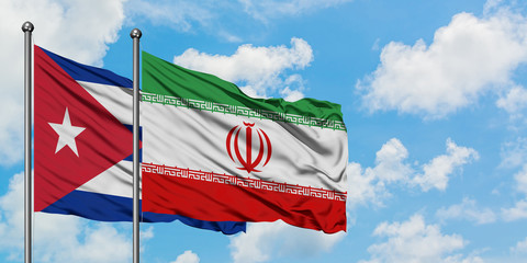 Cuba and Iran flag waving in the wind against white cloudy blue sky together. Diplomacy concept, international relations.
