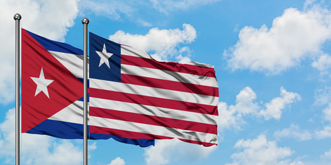 Cuba and Liberia flag waving in the wind against white cloudy blue sky together. Diplomacy concept, international relations.