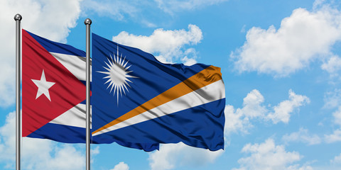 Cuba and Marshall Islands flag waving in the wind against white cloudy blue sky together. Diplomacy concept, international relations.